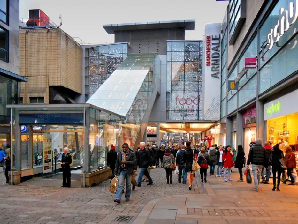 Crowds shop in an open-air mall under glass structures and festive lights. — Arndale Food Market, Manchester