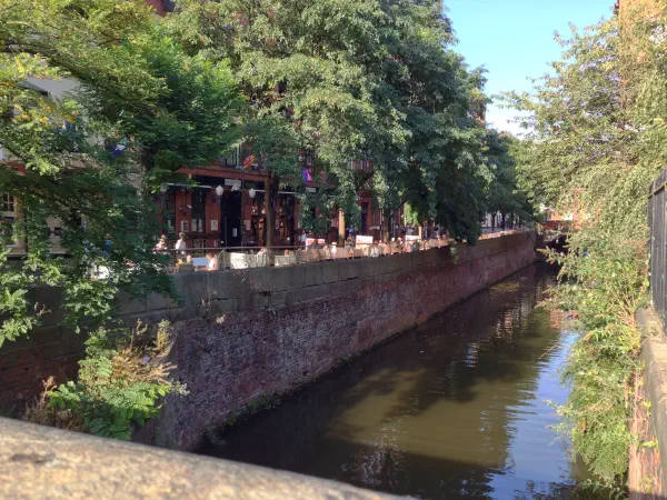 A sunny day on a canal lined with trees and brick walls. — Canal Street, Manchester