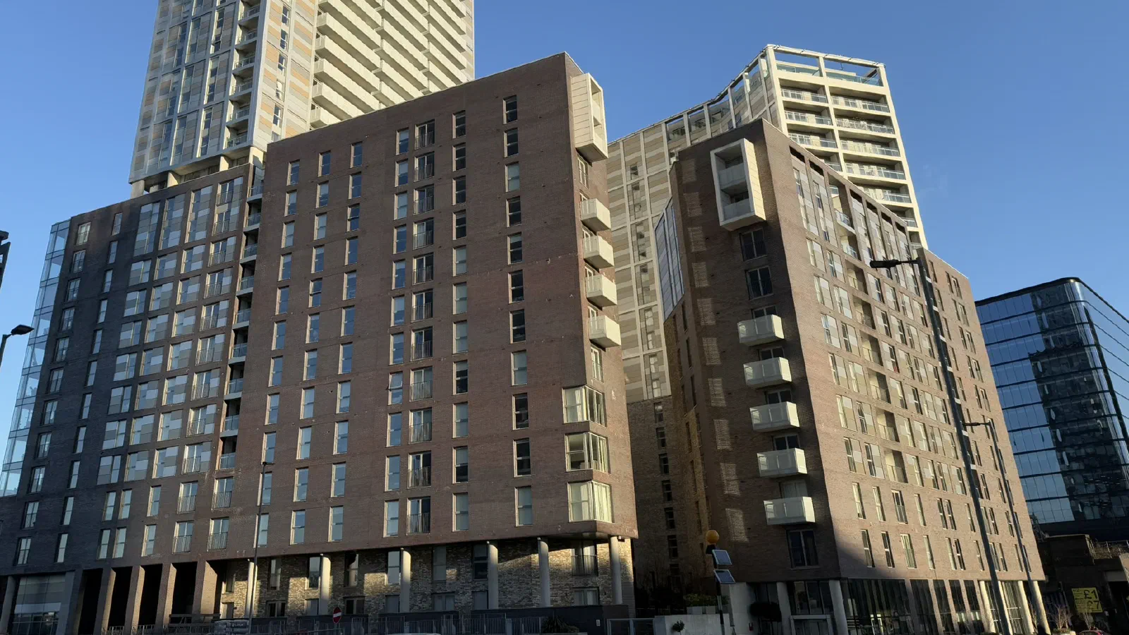 Tall brick apartment buildings under a clear blue sky on a sunny day. — Greengate, Manchester