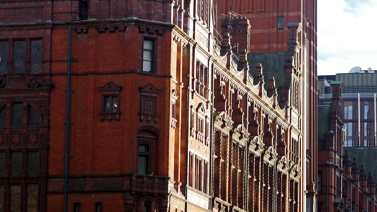 Red brick building stands tall against a clear blue sky with clock tower and green dome under bright sunlight. — Kimpton Clocktower Hotel (The Refuge), Manchester
