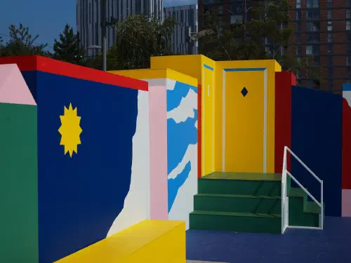 Vibrant colorful painted blocks with geometric shapes under bright sky near modern building