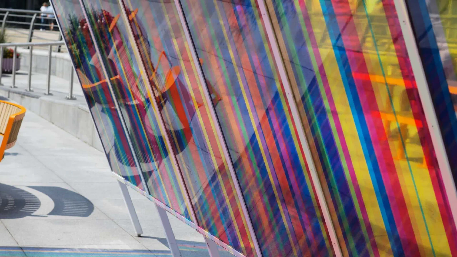 Rainbow stripes on colorful transparent panels cast vibrant shadows. — MediaCityUK, Manchester