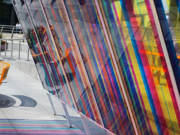 Rainbow stripes on colorful transparent panels cast vibrant shadows. — MediaCityUK, Manchester
