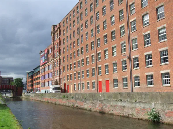 Red brick building beside canal under gray sky. — Murrays' Mills, Manchester