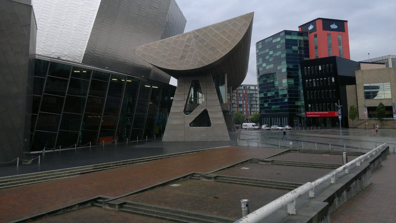 Overcast city scene with modern architecture featuring glass facades, metal structures and geometric designs. — The Lowry, Manchester